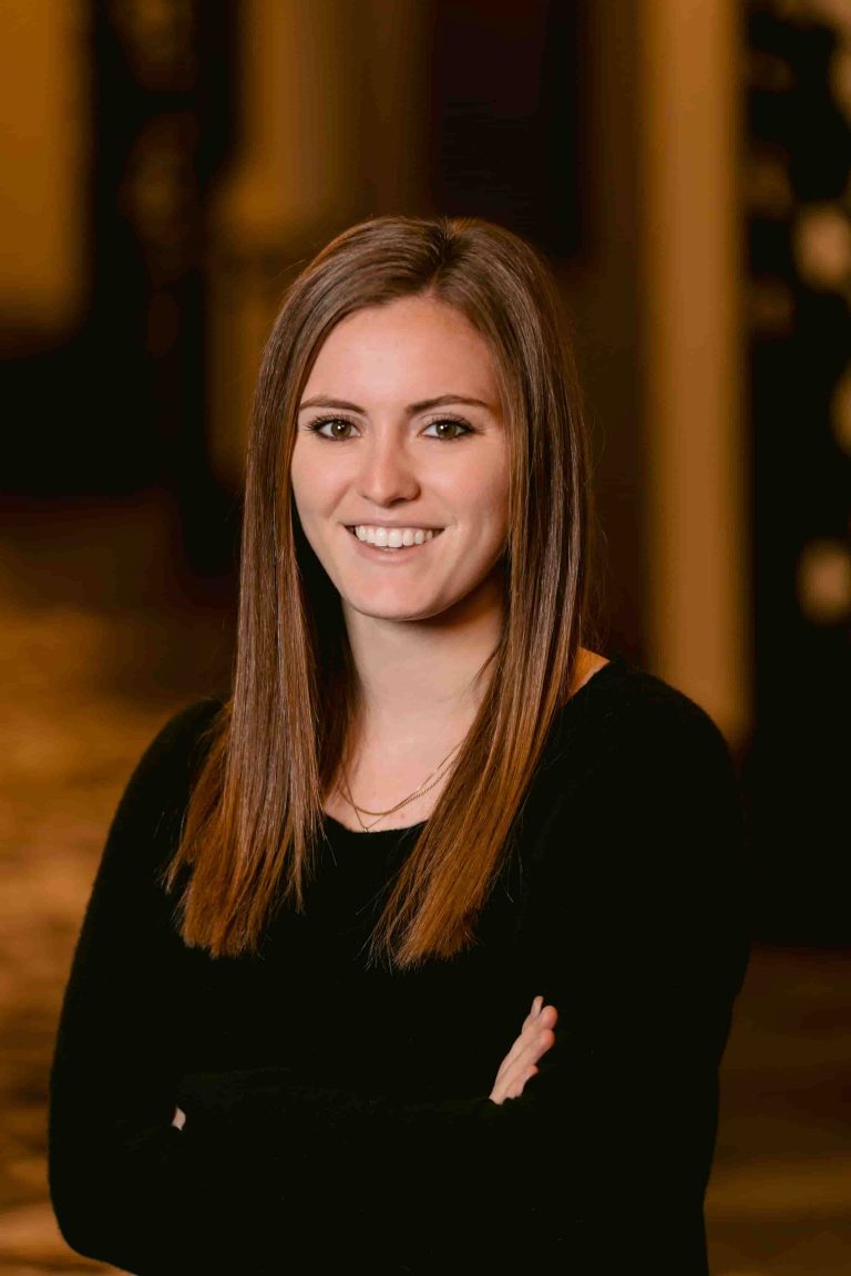 A photo of a moving grant recipient wearing a black shirt with her arms folded