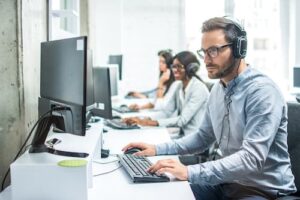 Man and two women at working in an home security monitoring center