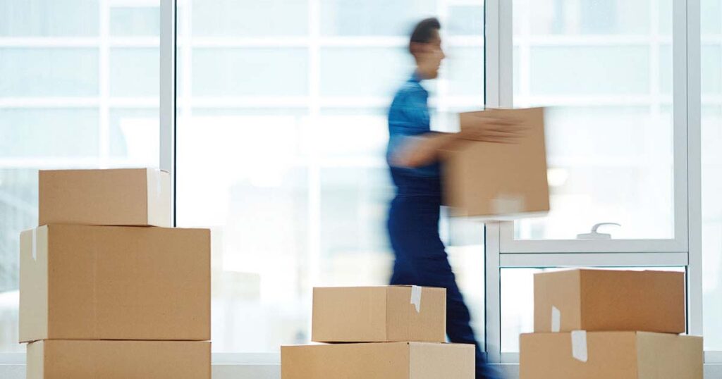 blurred image of person moving boxes