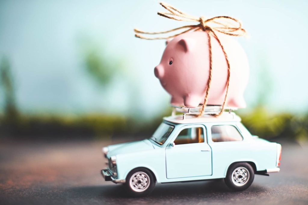 A car with a piggy bank on top