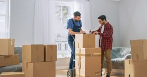 A man signing papers with a mover