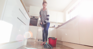 Woman mopping a floor in a kitchen